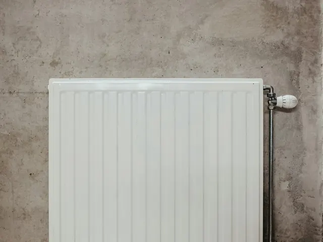 Radiateur blanc posé sur un mur en béton
